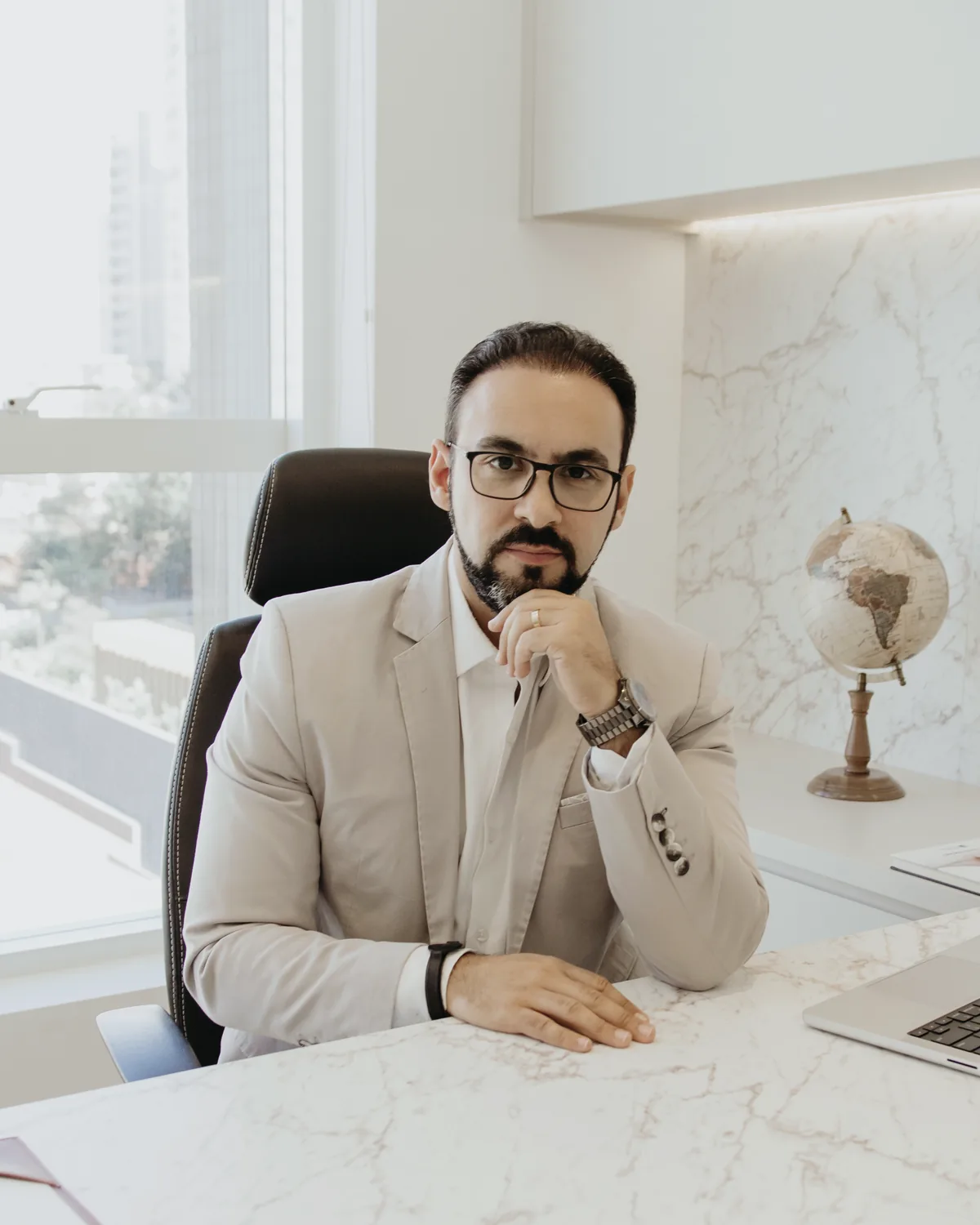 Dr. Guilherme Antonangelo à mesa, atento, com a mão no queixo