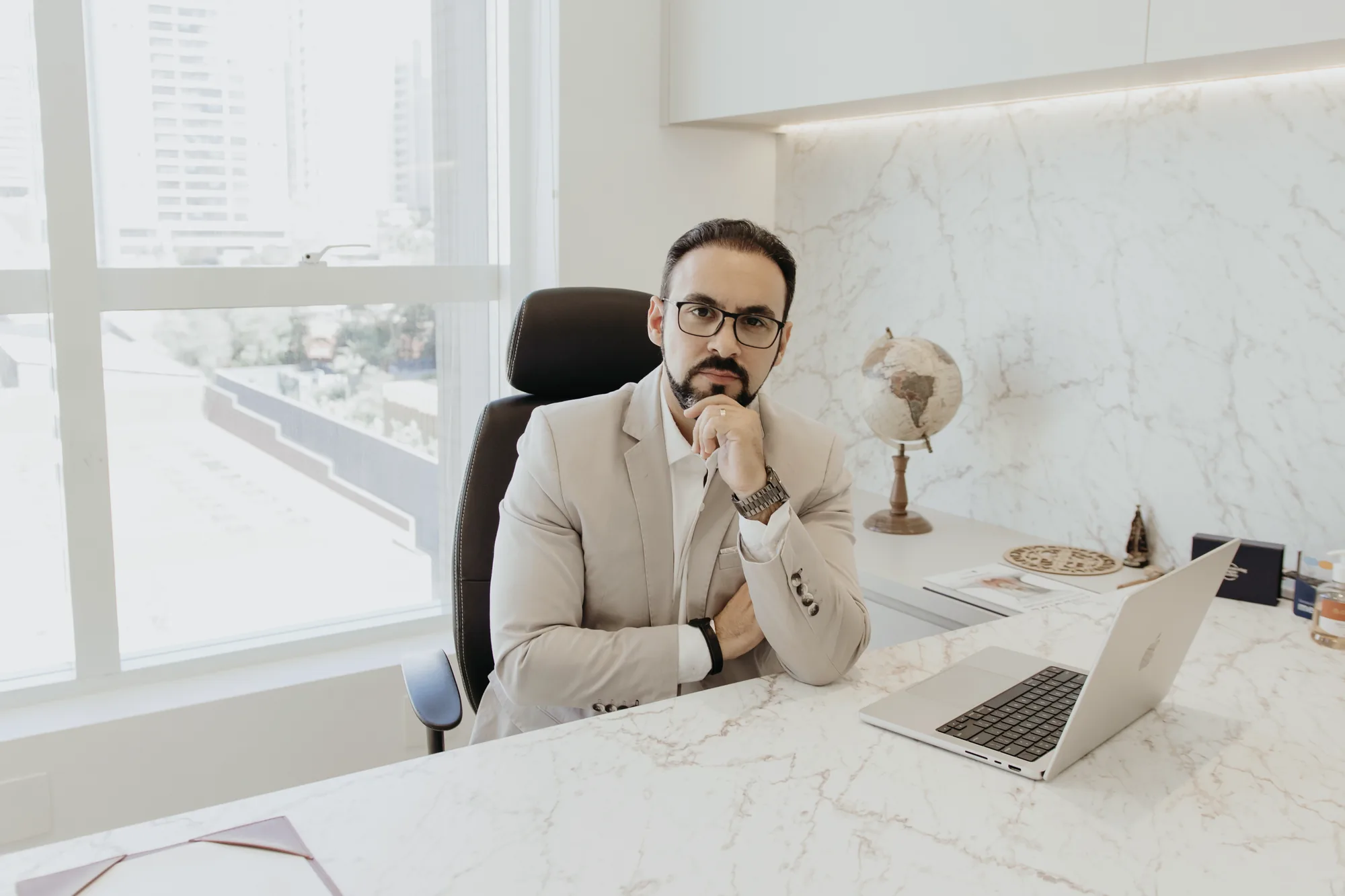 Dr. Guilherme Antonangelo à mesa de mármore do consultório