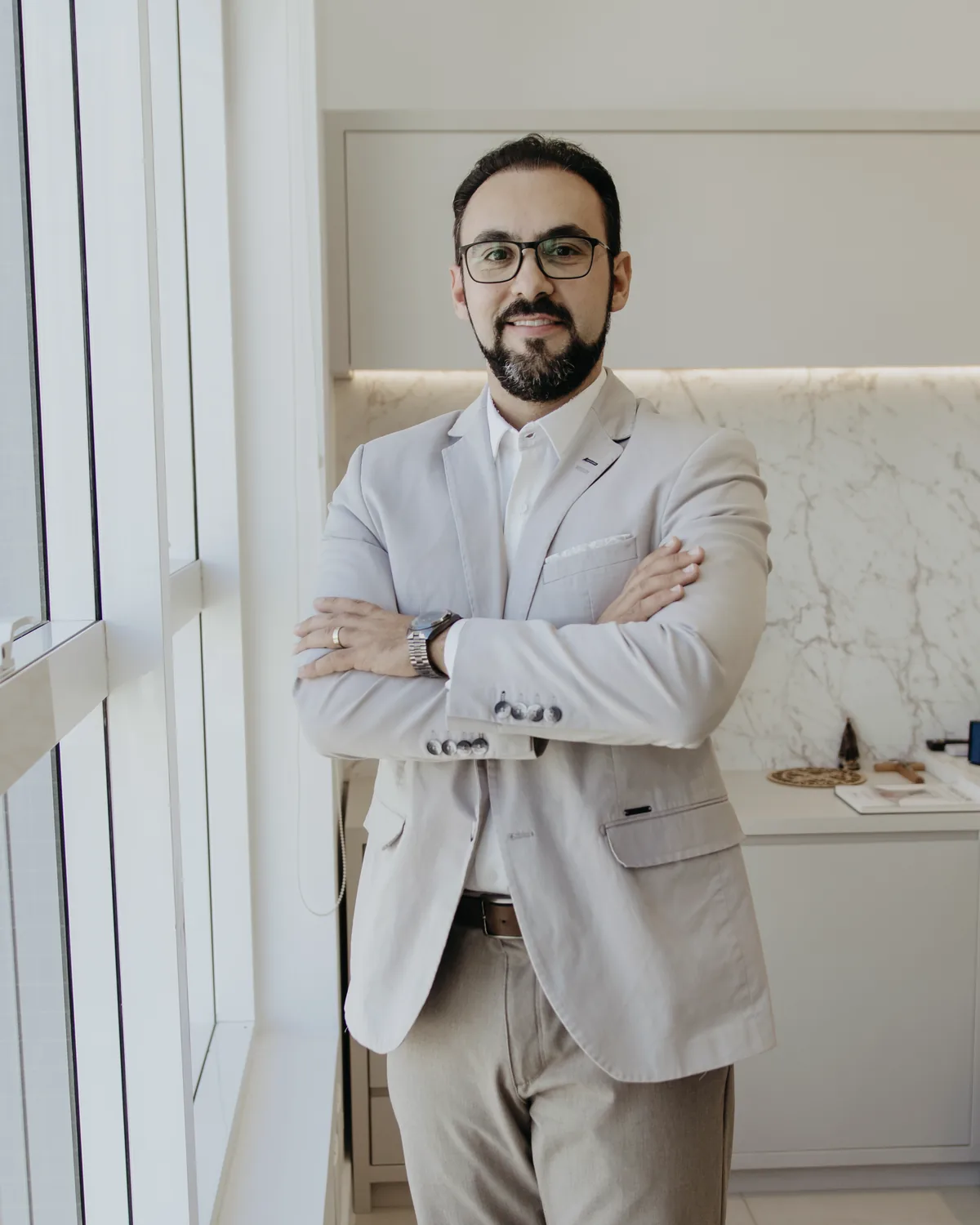 Dr. Guilherme Antonangelo de braços cruzados no consultório